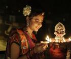 Γυναίκα χαμηλώματος με μια λάμπα πετρελαίου στο δικό της χέρι στον εορτασμό της Diwali